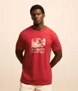 Remera de algodón color rojo con estampa centralizada de viaje a la playa.