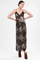 Falda midi color verde oscuro con estampado de ángeles y edificios en tonos grises, con elástico en la cintura y detalle de puntilla negra en el ruedo.