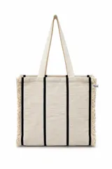 Bolso tote bag tejido a mano en color beige con rayas verticales negras y bordes deshilachados. Tiene dos asas de mano.