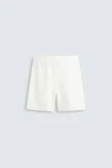 Bermuda de algodón color marrón oscuro, de corte regular fit, con cintura elástica ajustable mediante cordón. Presenta bolsillos laterales y un bolsillo trasero de vivo.