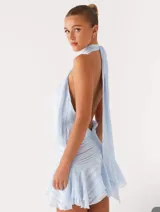 Vestido corto celeste con finas rayas verticales blancas, cuello halter fruncido y cintura y ruedo con frunces.