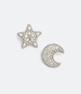 Par de caravanas asimétricas plateadas con strass. Una caravana tiene forma de luna y la otra de estrella.