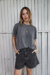 Remera gris lavado de corte boxy con costuras en color contrastante y bordado de una estrella en el frente.