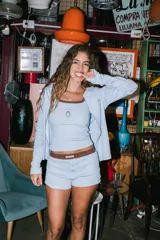 Musculosa de punto acanalado color celeste, con ribete marrón en el cuello y las sisas, y un pequeño bordado de fresa en el pecho.