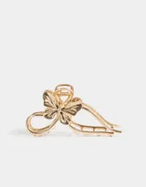 Broche dorado para el pelo con forma de moño y mariposa.