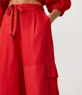 Conjunto de top corto con escote en V y mangas abullonadas, y pantalón palazzo con bolsillos cargo y lazo en la cintura, ambos en color rojo.