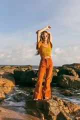 Top tejido color naranja con lurex, escote cuadrado y volados en los hombros.