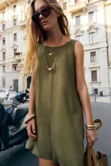 Mono corto color verde militar confeccionado en lino 100%. Tiene cuello redondo, sisa y espalda descubierta. Presenta bolsillos laterales ocultos en costuras.