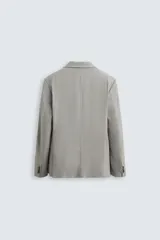 Blazer regular fit confeccionado en tejido con lana. Cuello con solapas de muesca. Manga larga acabada en puño con detalle de botones. Bolsillo de vivo en pecho y de solapa en cadera. Detalle bolsillo interior. Bajo con aberturas en espalda. Cierre frontal con botones.
