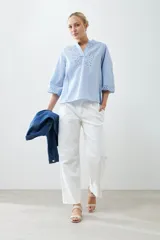 Blusa celeste con escote en V y bordado floral en el frente y en las mangas 3/4.