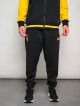 Pantalón de jogging negro con puños ajustados y logo del Club Atlético Peñarol bordado en dorado.