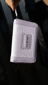 Billetera mediana color beige con textura croco, cierre alrededor y logo Lincoln's.