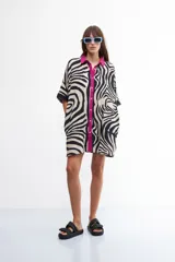 Vestido camisero con estampado de cebra, cuello camisero con vivos fucsia y corte holgado.