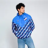 Campera deportiva Umbro Windbreaker del Club Nacional de Football. Diseño con paneles en azul y estampado geométrico en azul, rojo y blanco. Incluye capucha, cierre frontal y logo de Umbro y escudo del club en el pecho.