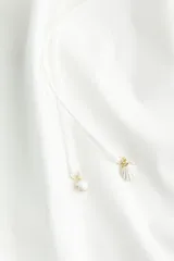 Vestido corto evasé de algodón blanco, con mangas globo cortas de diseño raglán, escote redondo con cordón para ajustar y corte holgado.