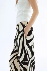 Pantalón tobillero de viscosa con estampado abstracto en blanco y negro, tiro alto con elástico en la cintura, bolsillos laterales y piernas amplias rectas.
