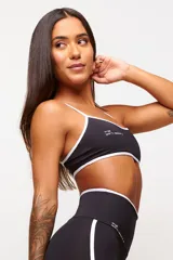 Top deportivo color rojo con detalles en blanco, diseño ajustado y asas ajustables, fabricado en poliamida de alto rendimiento.