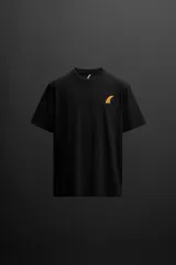 Camiseta negra de algodón con calce relaxed fit, cuello redondo y manga corta. Estampado pequeño en el pecho con la silueta de una quilla de tabla de surf color naranja.