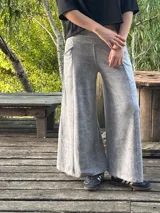 Pantalón palazzo de tiro alto confeccionado en viscosa y spandex con efecto batik en color gris. Posee un diseño de pierna ancha evasé, bolsillos laterales y una faja ancha en la cintura.