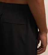 Bermuda negra de poliéster con cintura elastizada ajustable con cordón, bolsillo trasero y etiqueta gomosa en el frente.