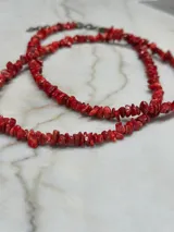 Collar largo de cuentas rojas y amarillas.