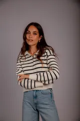 Sweater de punto color beige con rayas horizontales blancas, cuello polo con cierre de cremallera y mangas largas.