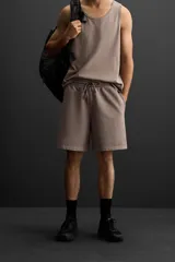 Bermuda jogger negra confeccionada en tejido de algodón con interior de rizo, cintura elástica ajustable con cordón y bolsillos laterales.