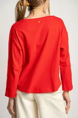 Sweater rojo de algodón con textura y corte oversize. Tiene mangas largas con dos rayas blancas en los brazos.