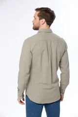 Camisa de lino color beige, de manga larga, con cuello clásico y bolsillo en el pecho.