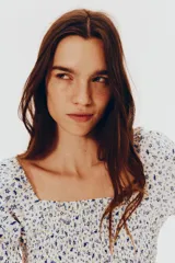 Vestido corto de popelina de algodón con estampado floral azul. Presenta escote cuadrado con elástico, mangas cortas abullonadas con fruncido elástico, cuerpo ajustado fruncido y falda con vuelo.
