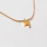 Collar dorado con cadena fina y dije de rayo.