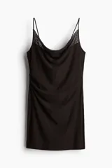 Vestido corto negro de malla con breteles spaghetti y escote drapeado. Tiene frunces en un lateral y forro de punto.