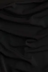 Top negro ajustado de punto elástico transparente, con mangas largas y escote drapeado.