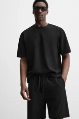 Bermuda negra de corte relaxed fit, con cintura elástica ajustable con cordón, bolsillos frontales y bolsillo trasero de parche.