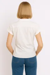 Camisa blanca de mangas cortas con dobladillo y nudo en la parte inferior.
