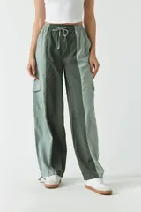 Pantalón verde con corte ancho, bolsillos laterales y cintura ajustable con cordón.