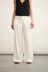 Pantalón de vestir blanco de corte palazzo con pinzas en la cintura.