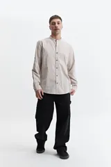 Camisa azul de manga larga con cuello mao y cartera abotonada.