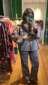 Chaqueta corta de paño de lana azul con detalles de crochet en rojo y verde.