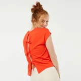 Camiseta roja de manga corta con espalda abierta y lazos decorativos.