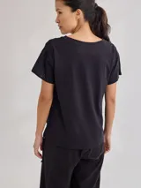 Remera negra de algodón con mangas cortas con detalle de calado y bordado en los hombros y mangas. Corte recto con cintura ajustable con cordón.