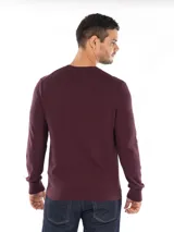 Sweater de punto color borgoña, de algodón, con cuello redondo, puños y dobladillo acanalados y logo CK bordado en el pecho. Corte regular.