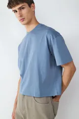 Camiseta celeste de corte amplio y cuello redondo, confeccionada en 100% algodón.