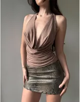 Top negro con escote halter profundo y detalle de tachas plateadas.