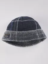 Gorro de lana azul marino con diseño a cuadros y borde de piel sintética gris.
