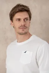 Remera azul con cuello redondo, manga corta, bolsillo en el pecho y logo bordado.