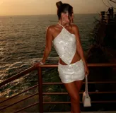 Top blanco con lentejuelas, escote halter y espalda descubierta.