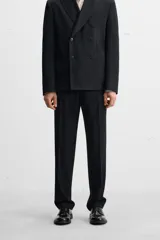 Pantalón de vestir negro slim fit confeccionado en tejido de lana de origen italiano. Cuenta con bolsillos frontales y traseros de vivo con botón. Cierre frontal con cremallera y botón. Colección especial Origins.