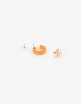 Set de tres pares de aros: un par de aros pasantes con perlas, un par de aros pasantes con forma de flor dorada y un par de aros argolla de resina translúcida color naranja.