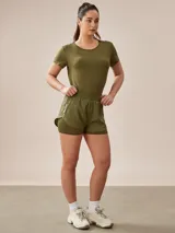 Short deportivo verde militar con calza interna, cintura elástica y logo estampado en la pierna.